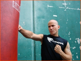 A man is standing in front of a punching bag