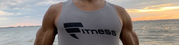 A man wearing a gray shirt with the word fitness on it.